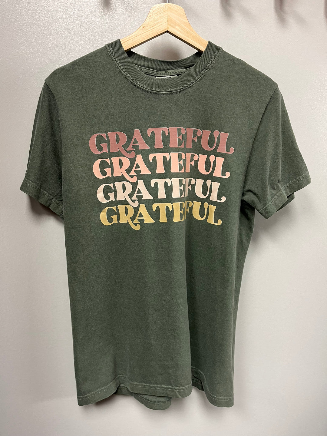 Moss green tshirt with the word ‘GRATEFUL’ repeated on the front
