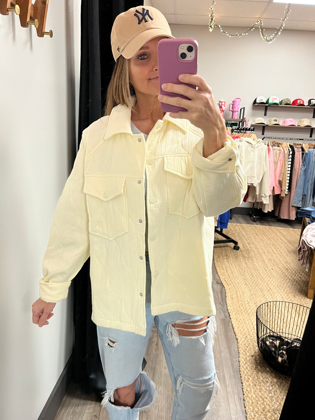 Cream quilted jacket with a lapel collar and long raglan sleeves, button snaps