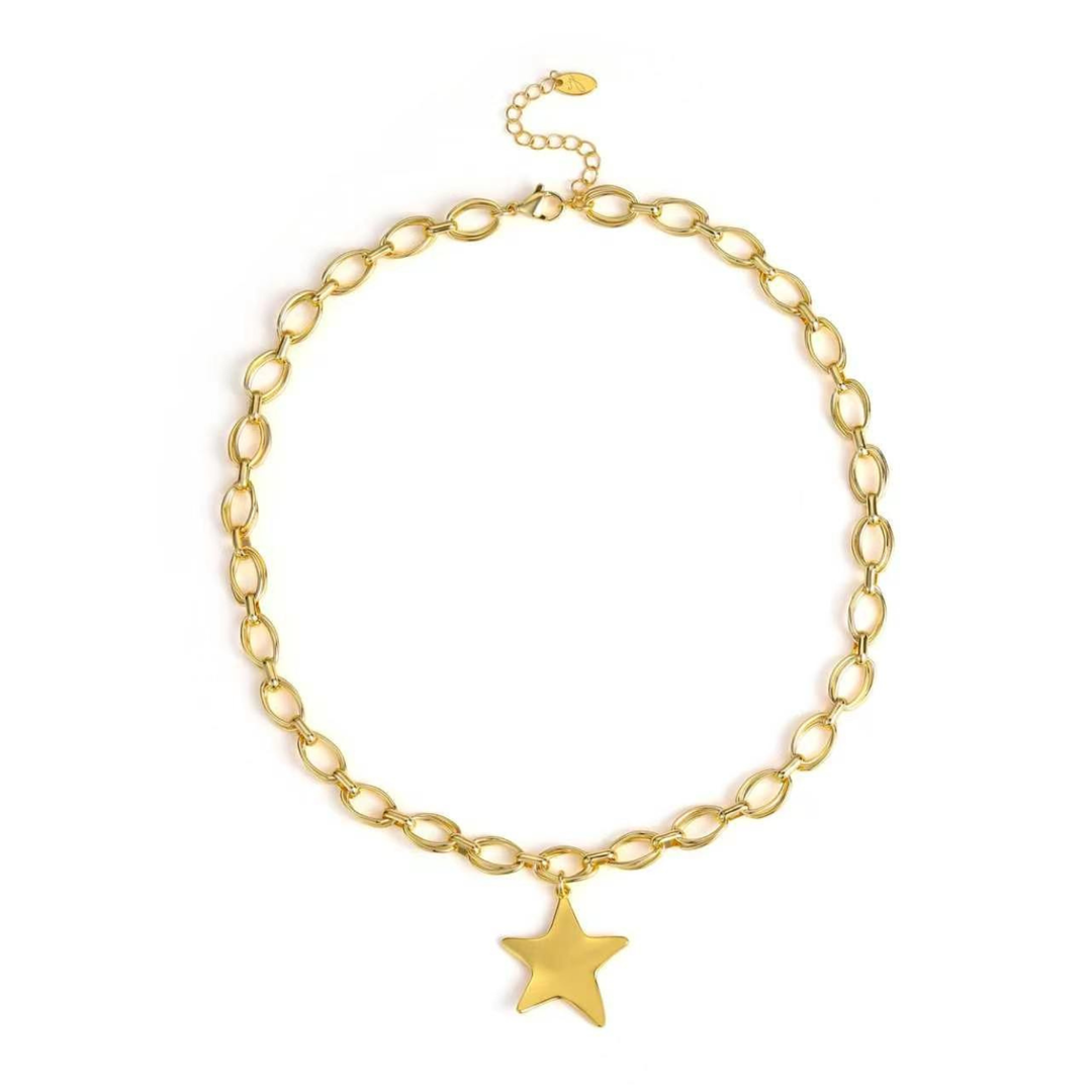 A gold chain necklace with elongated oval links and a dangling star-shaped charm, displayed on a clean white background.