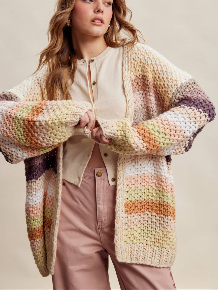 Woman wearing a colorful knitted cardigan on a plain background