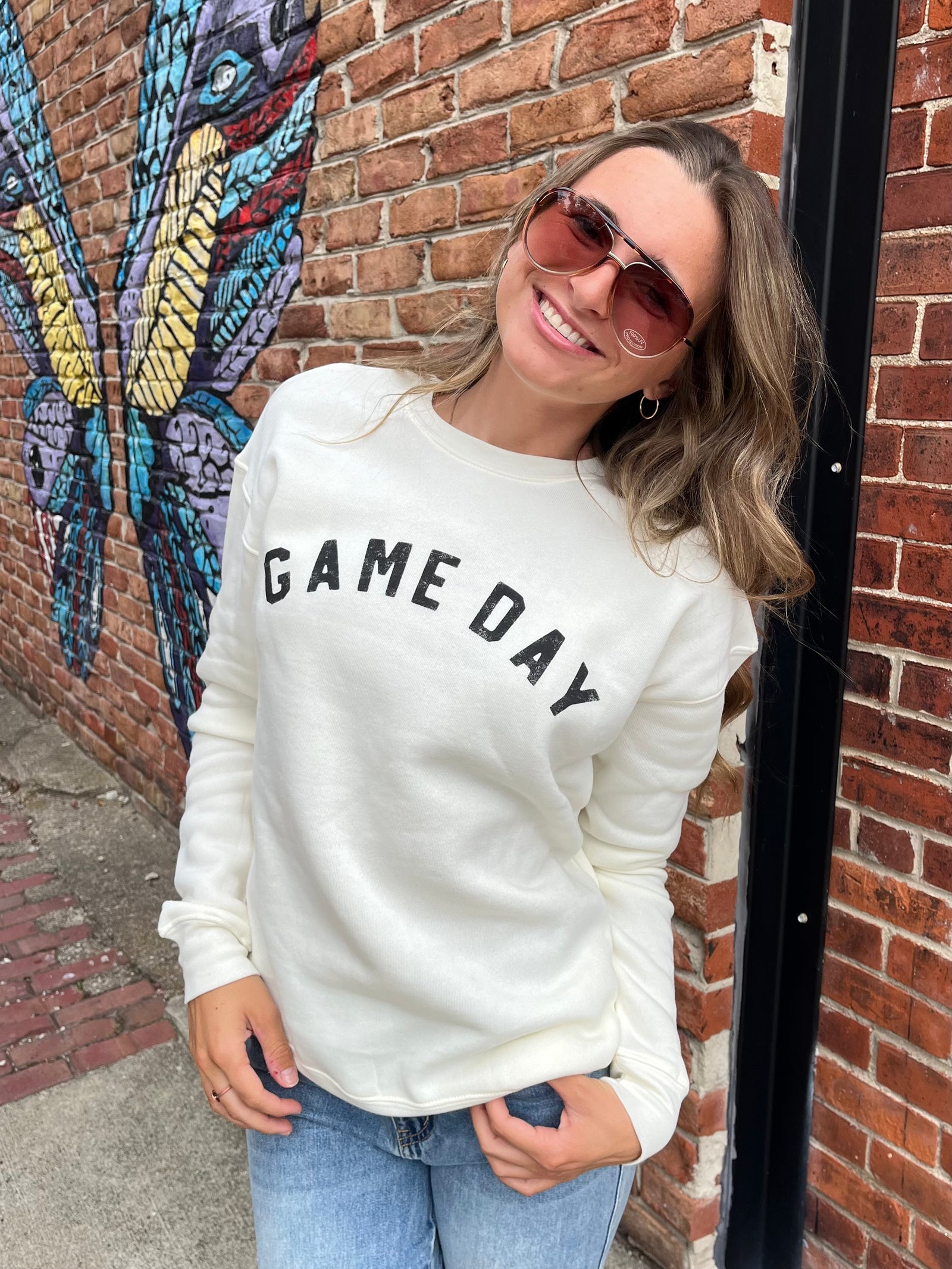 White crew neck sweatshirt with the text 'GAME DAY' on the front