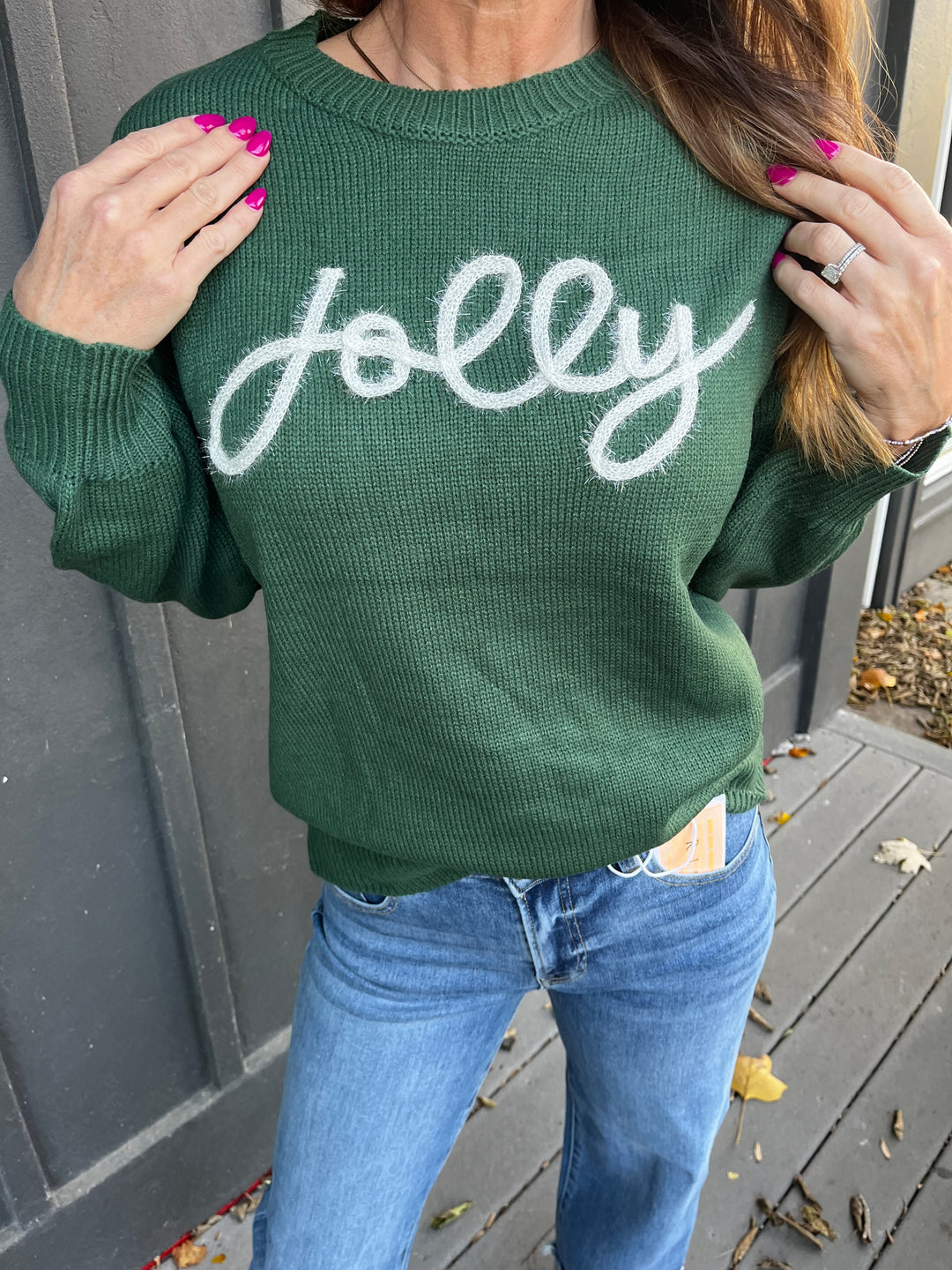 Green holiday sweater with Jolly embroidered on it