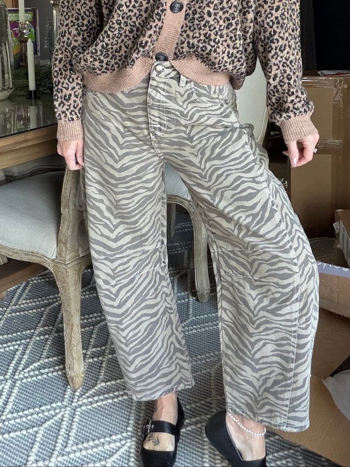 Person wearing a leopard print sweater and zebra pattern pants in an indoor setting.