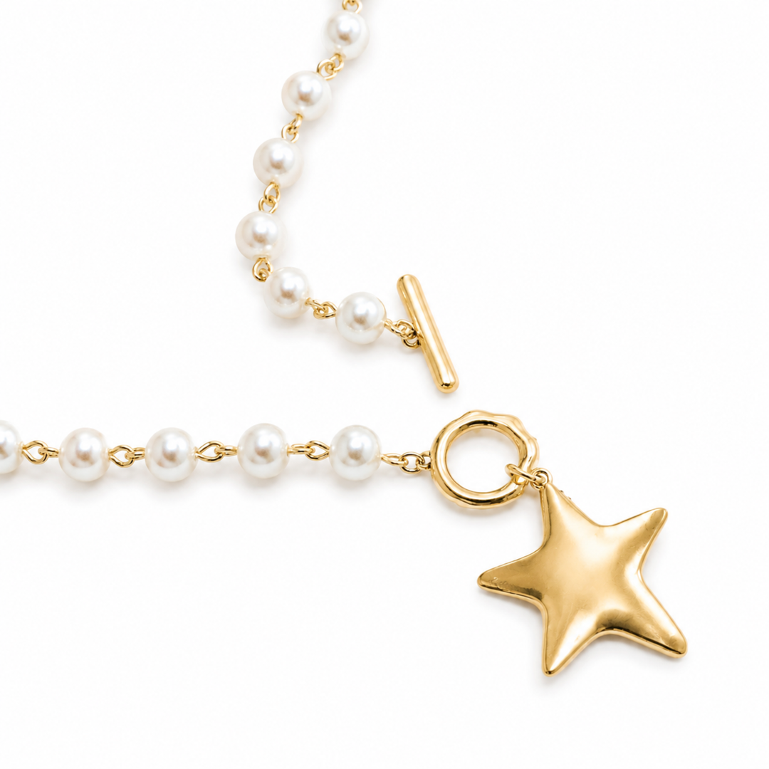 Pearl necklace with a gold star pendant on a white background