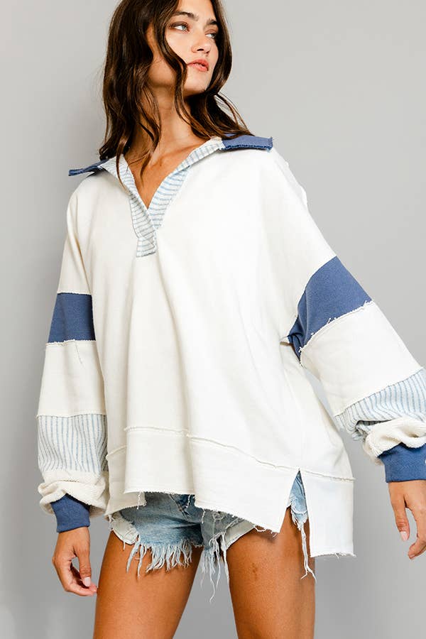 Woman wearing a white and blue striped sweater, v neck, oversized